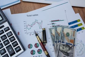 Fototapeta premium Top View of Financial Growth Graph with Cash and Computer for Corporate Sales Review Concept