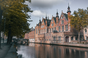 Naklejka premium Scenic canals and historic medieval architecture in Bruges, Belgium, featuring traditional Flemish buildings along the water in the iconic European city.