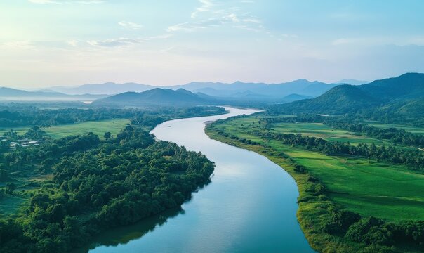 Scenic aerial view of a lush green river delta under a soft blue sky, natural lighting emphasizing the serene beauty of the environment