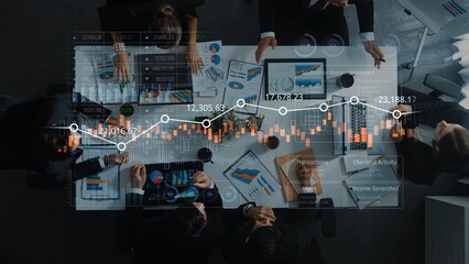 Naklejka premium Aerial perspective of a professional business team engaged in data analysis, discussing insights with digital charts and graphs on a conference table in a modern office setting. Raster