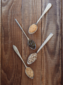 Healthy seeds varieties in spoons on wooden table