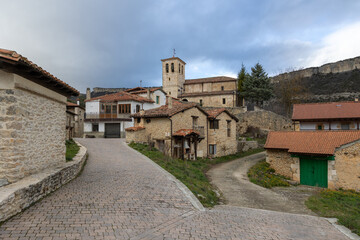 Fototapeta premium Puentedey village street leading to historic church in burgos
