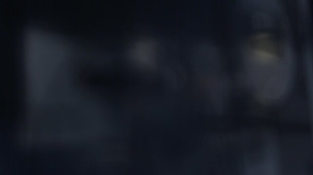 A cinematic close up shot showing a focus pull revealing a classic vintage film camera. The black camera setup features a matte box against a dark studio background.