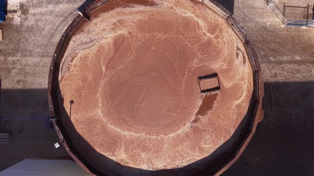 Vertical aerial view of a circular industrial clarifier used for sedimentation and solids separation in a process water treatment system within a large industrial facility