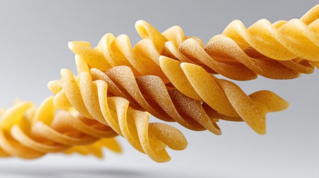Close-up of uncooked spaghetti and Fusilli pasta flying in air, isolated on clean white background, ideal for pasta packaging and culinary designs 