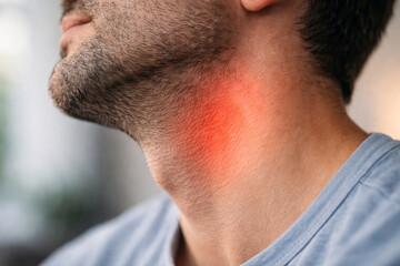 Close up of man with red highlighted area on neck indicating sore throat, inflammation or infection, concept of pain, illness and health problem.