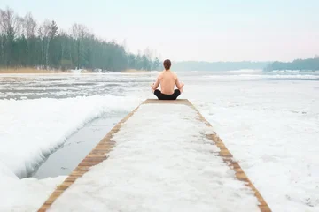 Fotobehang Lotusbloem Man meditating in lotus pose on snowy pier  © Kyrylo