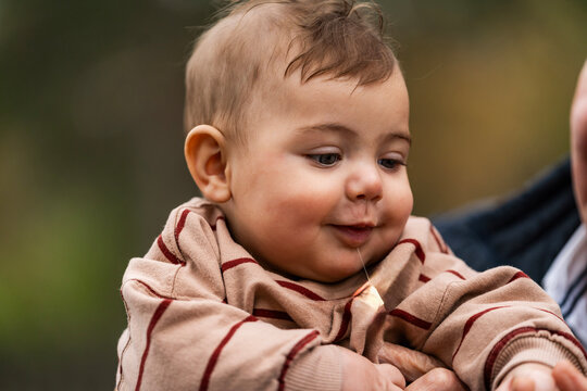 Baby drooling while being held by an adult