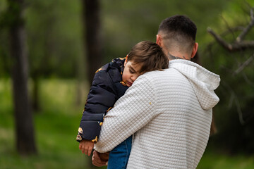 Fototapeta premium Parent carrying sleeping child, showing comfort and security