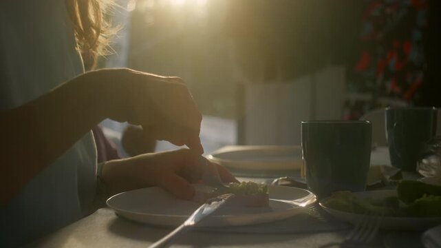 Making avocado tosts at sunset with family in a cozy setting near a window in the morning.
