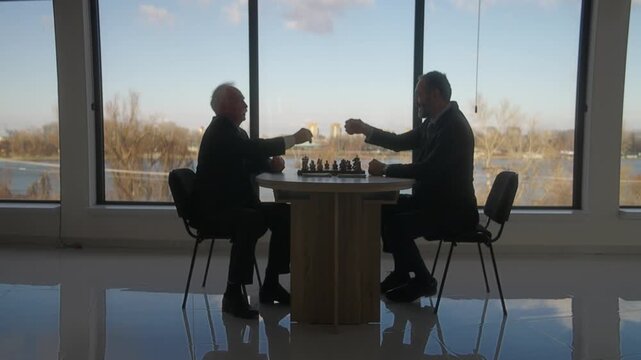 Middle Aged and Senior Businessmen Playing Chess for money in Office