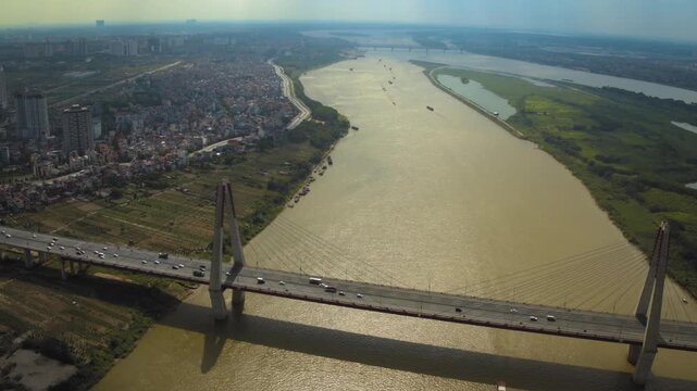 Breathtaking aerial footage flying over the nhat tan bridge crossing the expansive red river in hanoi