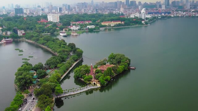 Aerial drone shot showing the tran quoc pagoda on an islet in the west lake of hanoi, vietnam