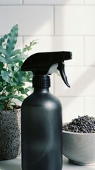 Matte black spray bottle beside potted plant and bowl of dried lavender on counter