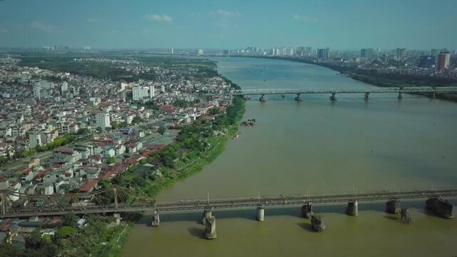 Panoramic aerial shot of hanoi's historic long bien bridge and modern cityscape along the red river