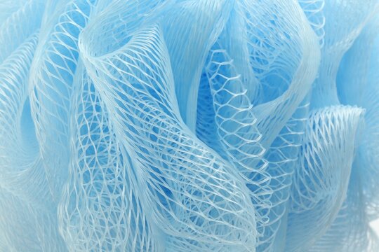 Blue mesh sponge as background, closeup. Shower accessory