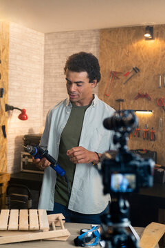 Handyman creating diy tutorial video with power drill