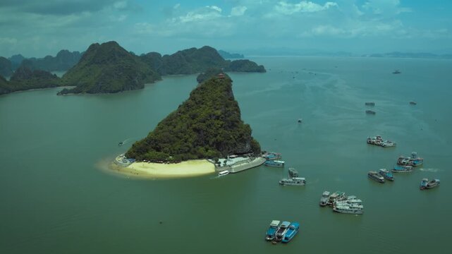 Breathtaking aerial footage of titop island with its sandy beach and tourist boats in halong bay