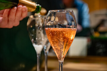 Naklejka premium Pouring in glasses of french sparkling wine champagne with little bubbles, tasting wine, celebration, wedding or champagne tour with visit of caves, Reims, France