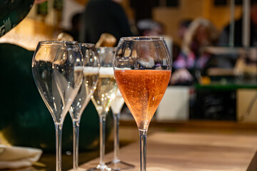 Naklejka premium Pouring in glasses of french sparkling wine champagne with little bubbles, tasting wine, celebration, wedding or champagne tour with visit of caves, Reims, France