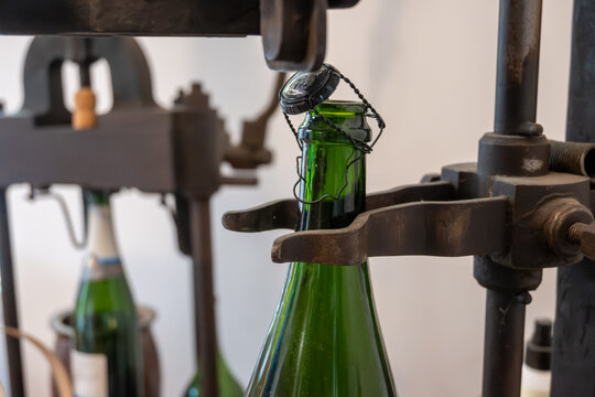 Old equipment for packaging champagne bottles, caps and muselet wire cage, traditional method making champagne sparkling wine in Reims, France