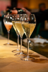 Fototapeta premium Pouring in glasses of french sparkling wine champagne with little bubbles, tasting wine, celebration, wedding or champagne tour with visit of caves, Reims, France