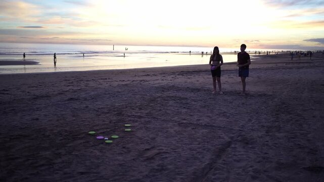 Couple playing beach game tejo at sunset