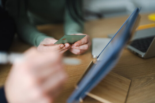 A person holds a credit card while using a tablet computer for online shopping or banking.