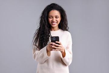 Fototapeta premium Beautiful young woman with smartphone on light grey background