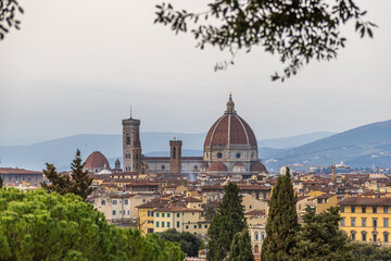 Tranquil Urban Panorama. Peaceful Urban View With Flourishing Greenery And Traditional Florence Rooftops Highlighted By Dawn Sunlight