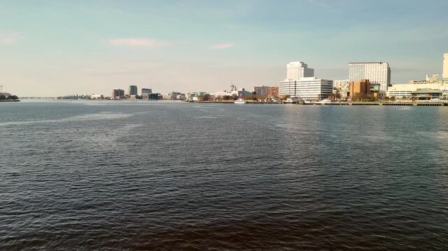 Aerial cinematic view of downtown Norfolk Virginia waterfront featuring Nauticus museum and the USS Wisconsin battleship