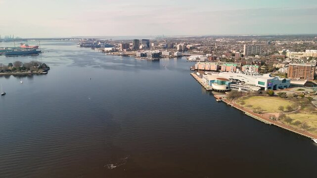 Aerial cinematic view of downtown Norfolk Virginia waterfront featuring Nauticus museum and the USS Wisconsin battleship
