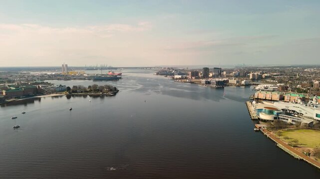 Aerial cinematic view of downtown Norfolk Virginia waterfront featuring Nauticus museum and the USS Wisconsin battleship