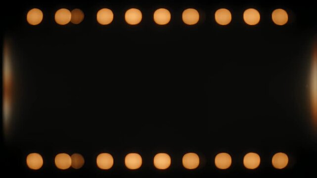 Abstract golden bokeh lights framing a dark rectangular space in the center