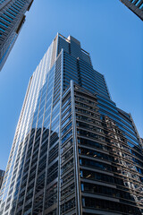 Obraz premium Business building. Glass building. Business city. City architecture. Modern glass building. Reflective glass architecture. Architecture in business district. Financial district. Building architecture