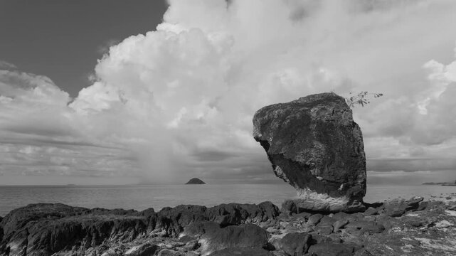 Dramatic monolithic rock stands on a rugged Fiji shoreline under a cloudy sky