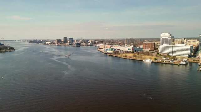 Aerial cinematic view of downtown Norfolk Virginia waterfront featuring Nauticus museum and the USS Wisconsin battleship