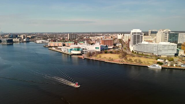 Aerial cinematic view of downtown Norfolk Virginia waterfront featuring Nauticus museum and the USS Wisconsin battleship