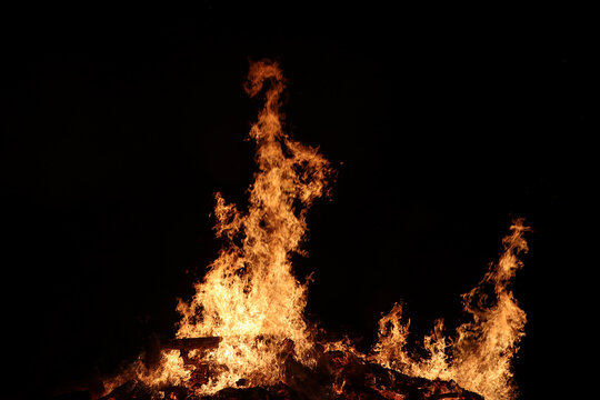 Ein gro&szlig;es brennendes Feuer aus Baumst&auml;mmen, freigestellt mit schwarzem Hintergrund
