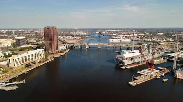 Aerial cinematic view of downtown Norfolk Virginia waterfront featuring Nauticus museum and the USS Wisconsin battleship