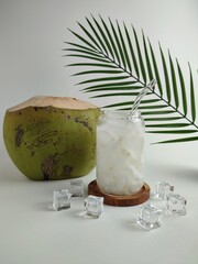 Fresh Coconut Water With Ice In Glass Jar And Whole Green Coconut