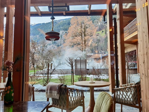 Luxury hotel lounge with view of outdoor heated pool in winter Alps for wellness marketing
