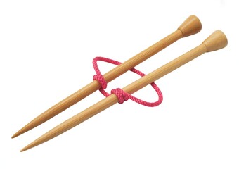 Two wooden knitting needles crossed with bright pink yarn tied around them bamboo