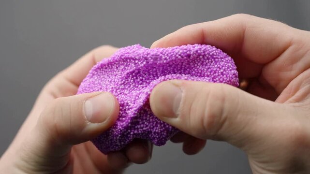 pink floam slime is stretched in a close-up creating a soft asmr sensory experience.