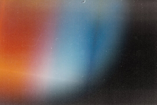 Vintage dual-tone light leak overlay with orange and cool blue glow. Heavy dust, scratches, and grain on dark background for retro cinematic video transitions and grunge effects.