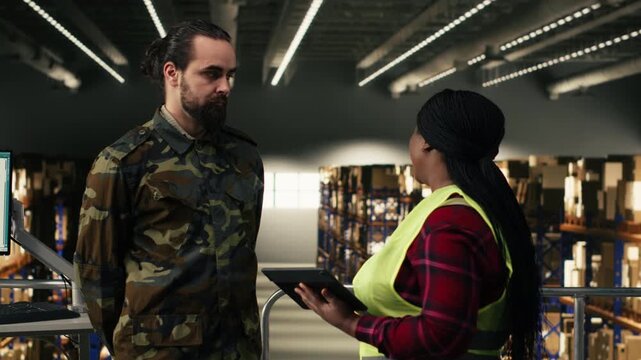 Diverse personnel coordinating supply chain for defense mission, reviewing tracking info for parcel shipment details. Man and woman ensuring management and infrastructure for tactical planning.