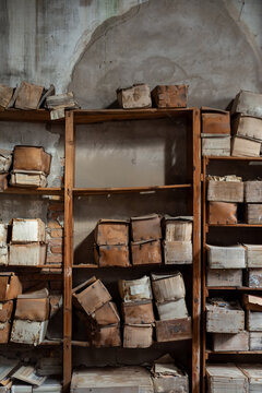Vintage shelving ancient cardboard boxes damaged humidity archive storage abandonment deterioration accumulation memory time preservation peeling wall bricks industrial
