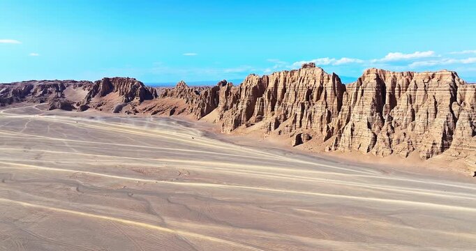 Aerial view of rugged jagged rock formations and a vast desert expanse in the remote wilderness of Xinjiang, China.