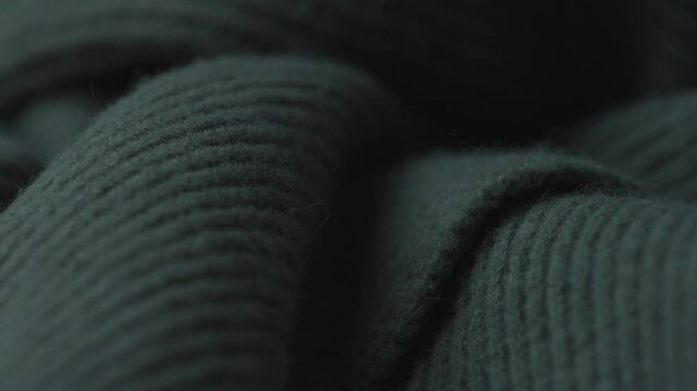 Close up of soft ribbed fabric texture in low light, abstract macro detail of woven material with subtle shadows and folds