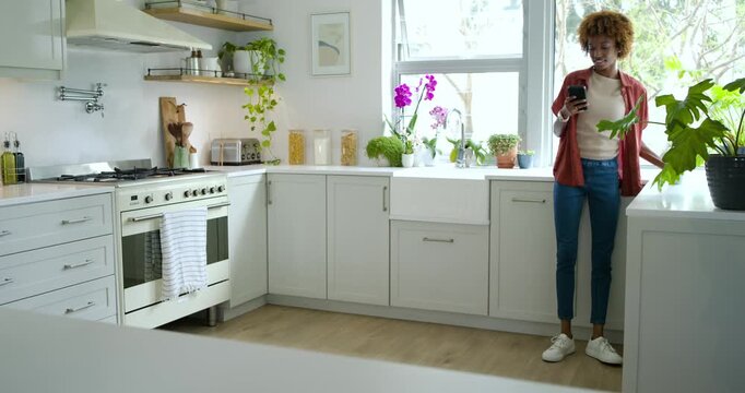 Adult African American woman entering kitchen after buzz scrolling phone smiling, copy space